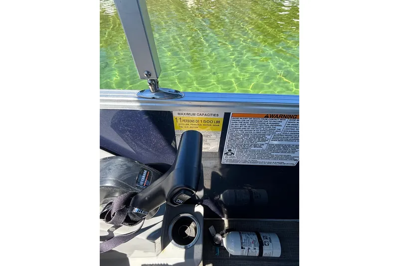 Slide: The Image of Control panel of 2022 Starcraft EX 22 Q boat with safety warnings and throttle lever. - 15