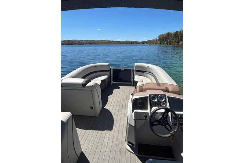 Slide: The Image of 2022 Starcraft EX 22 Q pontoon boat interior on a serene lake. - 5