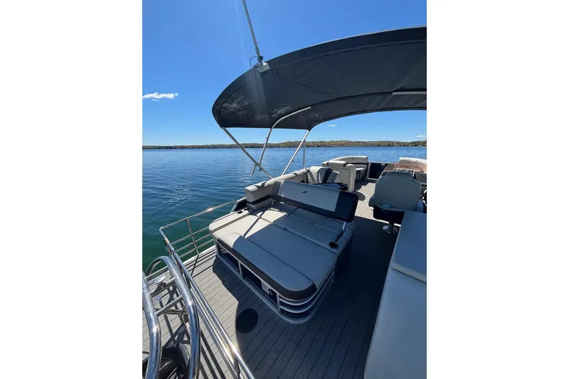 Slide: The Image of 2022 Starcraft EX 22 Q pontoon boat with spacious seating on a sunny lake. - 9