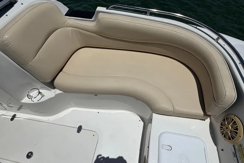 Slide: The Image of 2008 NauticStar 210 DC Sport Deck boat with beige cushioned seating and white deck. - 12