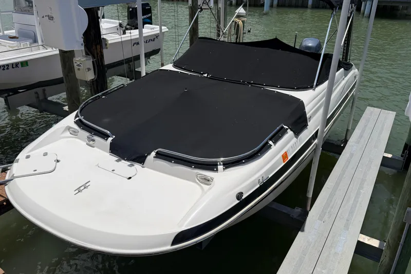 Slide: The Image of 2008 NauticStar 210 DC Sport Deck boat docked with black cover. - 19