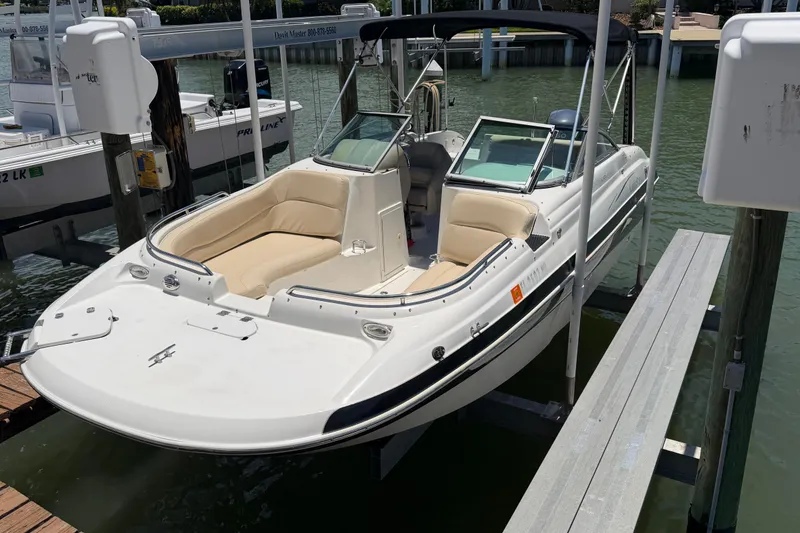 Slide: The Image of 2008 NauticStar 210 DC Sport Deck boat docked in marina, featuring beige seating. - 5