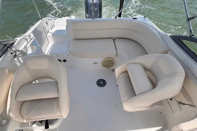 Slide: The Image of 2008 NauticStar 210 DC Sport Deck boat interior with beige seating on water. - 9