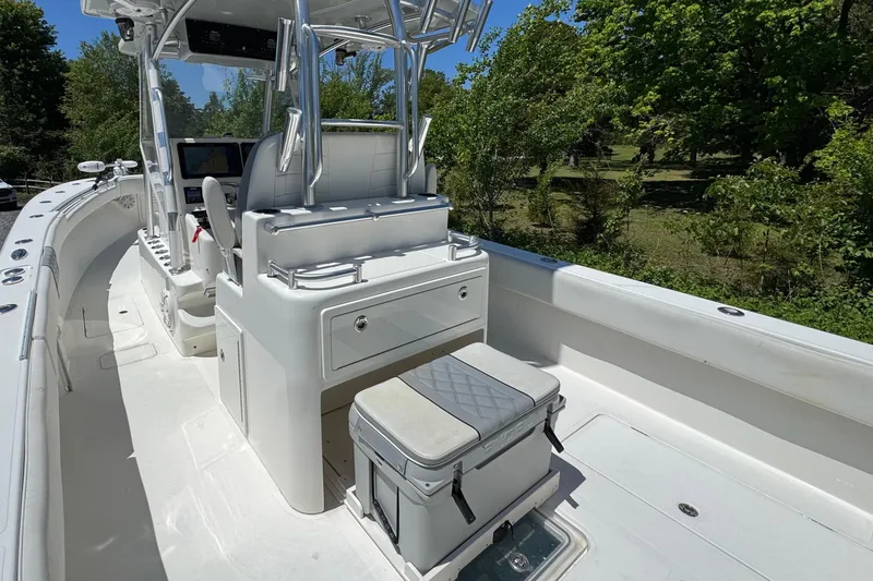 Slide: The Image of 2020 Sea-Lion 34 TE boat interior with seating and console, surrounded by lush greenery. - 10