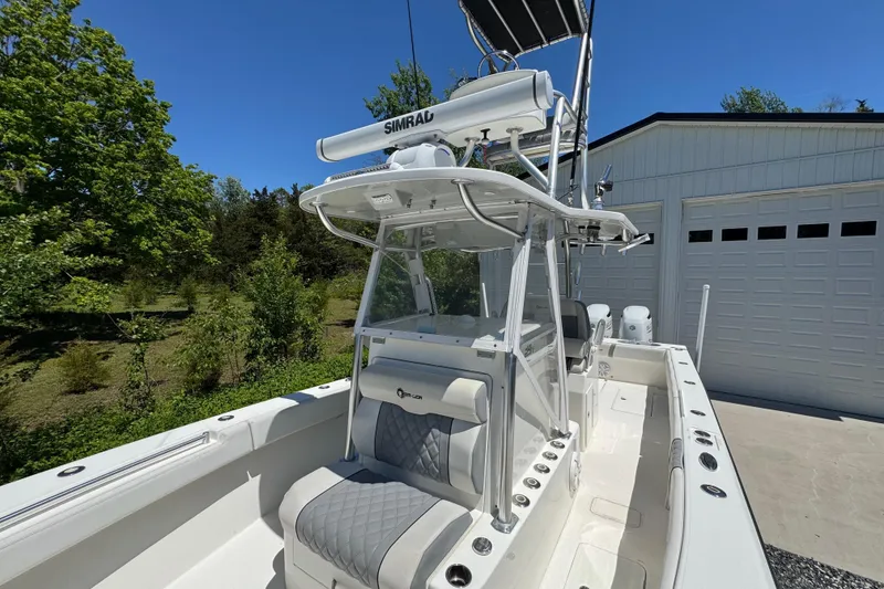 Slide: The Image of 2020 Sea-Lion 34 TE boat with Simrad equipment, parked near a garage under clear blue sky. - 16