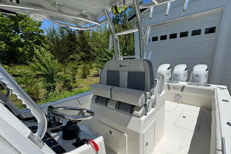Slide: The Image of 2020 Sea-Lion 34 TE boat interior with helm, seating, and triple outboard engines. - 8