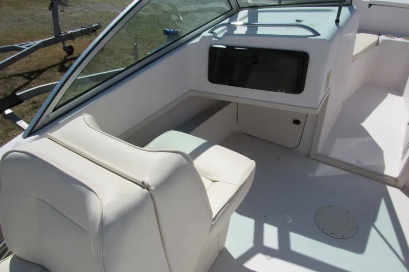 Slide: The Image of Interior of 2003 Grady-White Freedom 192 boat, featuring white seating and dashboard. - 12