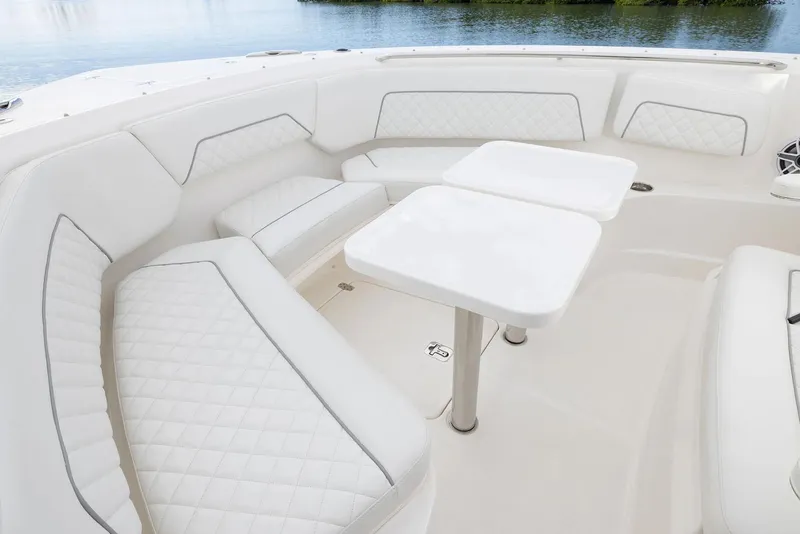Slide: The Image of Manufacturer Provided Image: Luxurious seating area on 2025 Pursuit S 328 Sport boat with white upholstery and tables. - 1