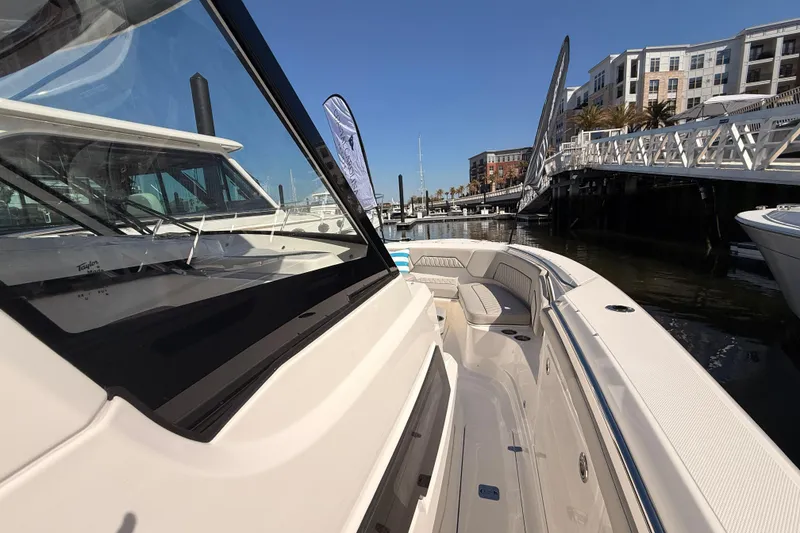Slide: The Image of 2026 Pursuit S 328 Sport boat docked at marina, showcasing sleek design and spacious seating. - 16