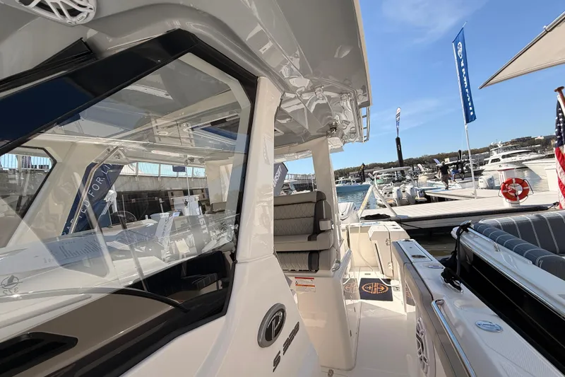 Slide: The Image of 2026 Pursuit S 328 Sport boat docked at marina, showcasing sleek design and seating. - 22