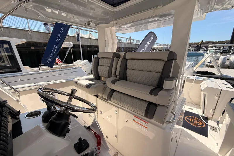 Slide: The Image of 2026 Pursuit S 328 Sport boat interior with luxurious seating and steering wheel. - 23