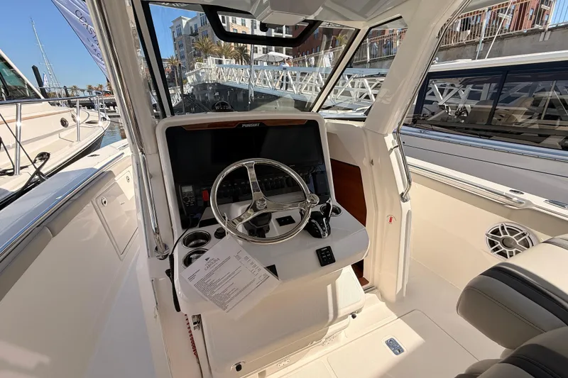 Slide: The Image of 2026 Pursuit S 328 Sport boat cockpit with steering wheel and control panel. - 24