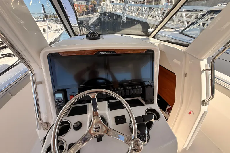 Slide: The Image of Helm of 2026 Pursuit S 328 Sport boat with modern controls and navigation display. - 25