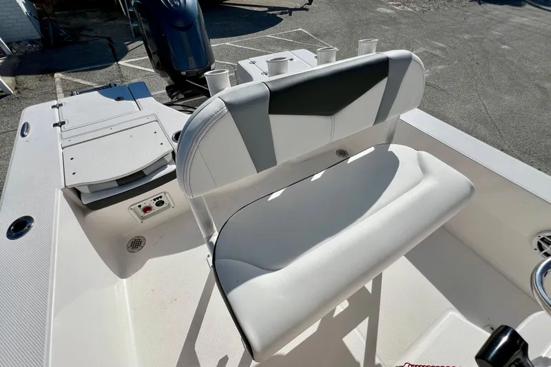 Slide: The Image of 2024 Robalo 206 Cayman boat interior with cushioned seating and fishing rod holders. - 13