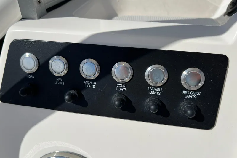Slide: The Image of Control panel of 2024 Robalo 206 Cayman boat with labeled switches for various lights and horn. - 17
