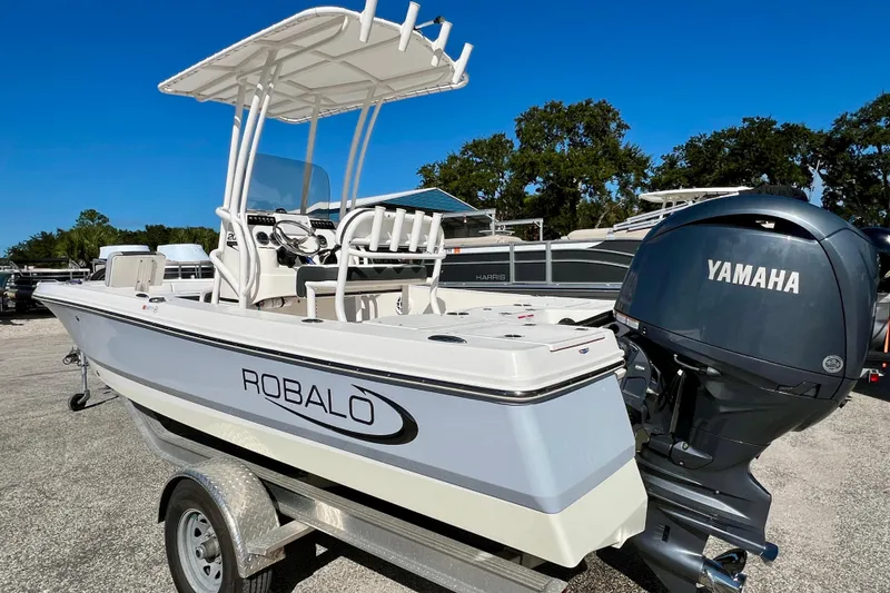 Slide: The Image of 2024 Robalo 206 Cayman boat with Yamaha engine on trailer, under clear blue sky. - 8