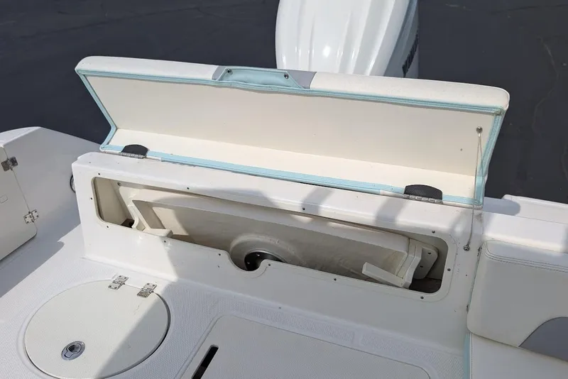Slide: The Image of 2022 Robalo R242 Explorer boat storage compartment open, showcasing interior space. - 19
