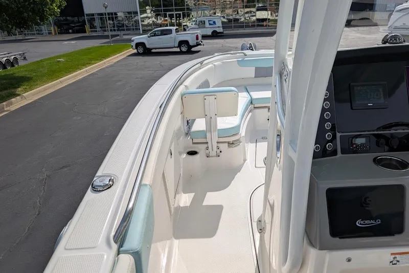 Slide: The Image of 2022 Robalo R242 Explorer boat interior with seating and control panel, parked outdoors. - 28