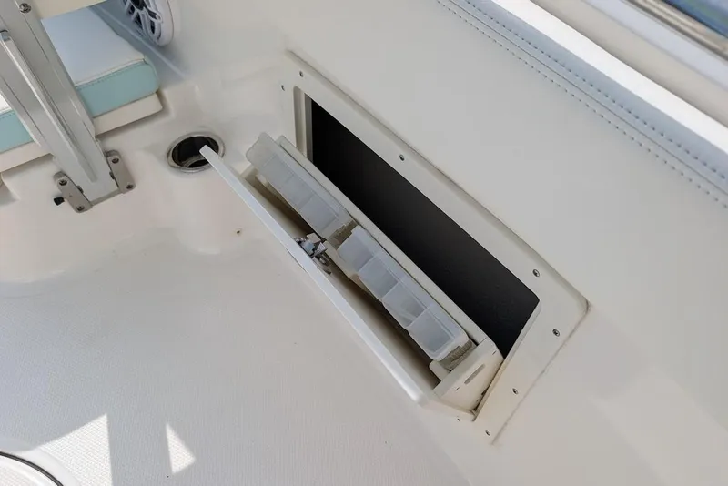 Slide: The Image of Storage compartment on 2022 Robalo R242 Explorer boat, featuring organized tackle boxes. - 31