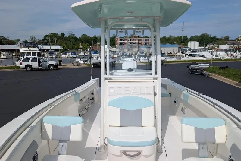 Slide: The Image of 2022 Robalo R242 Explorer boat interior at marina, featuring seating and console. - 38