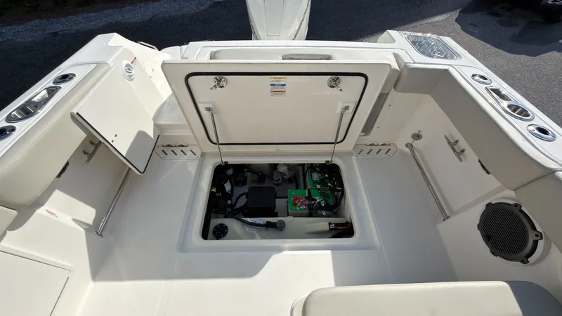 Slide: The Image of The image shows the storage area of a 2027 Boston Whaler 240 Vantage boat. The compartment is open, revealing various equipment and electronics. - 33