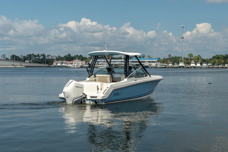 Slide: The Image of A 2027 Boston Whaler 240 Vantage on calm water. The sky is partly cloudy. - 3