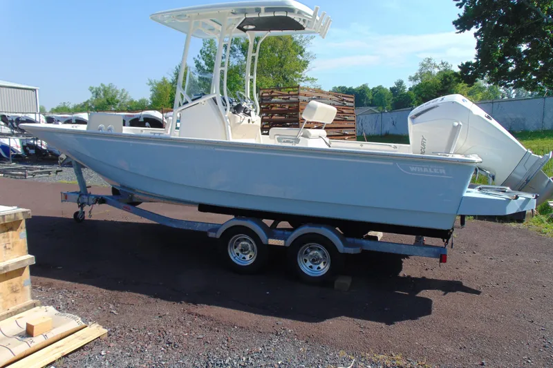 Slide: The Image of 2026 Boston Whaler 210 Montauk boat on trailer, parked outdoors. - 3