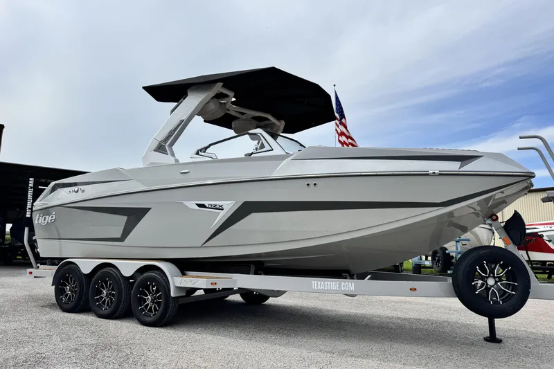 The Image of 2026 Tigé 24RZX boat on trailer, sleek design, American flag in background. - 1