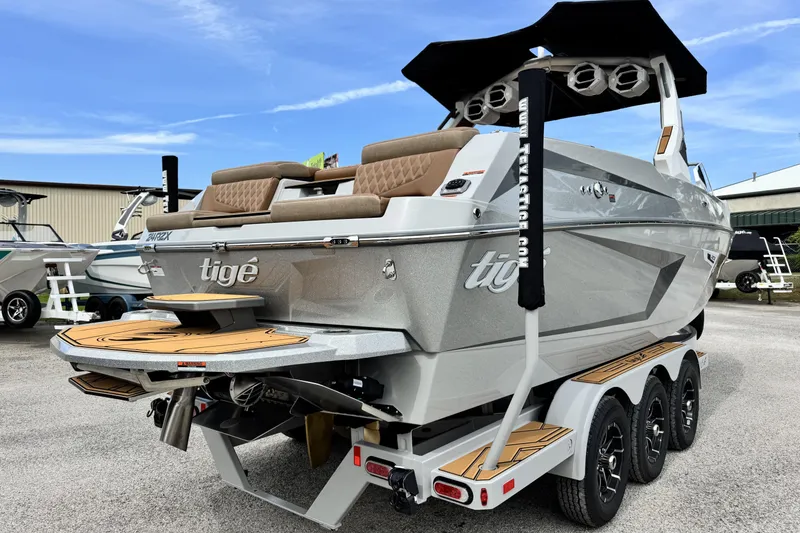 Slide: The Image of 2026 Tigé 24RZX boat with sleek design, triple-axle trailer, and luxurious seating. - 4