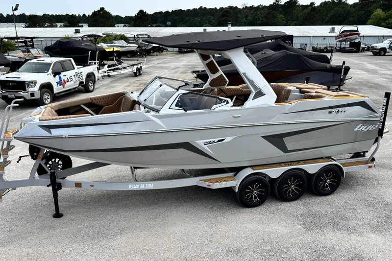 Slide: The Image of 2026 Tigé 24RZX boat on trailer, sleek design, parked at Texas Tigé Marine dealership. - 7