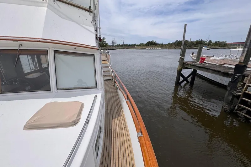 Slide: The Image of 1989 Grand Banks 42 Motoryacht docked by a serene waterfront. - 14