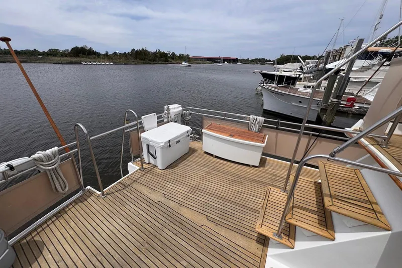 Slide: The Image of 1989 Grand Banks 42 Motoryacht deck with wooden flooring and marina view. - 19