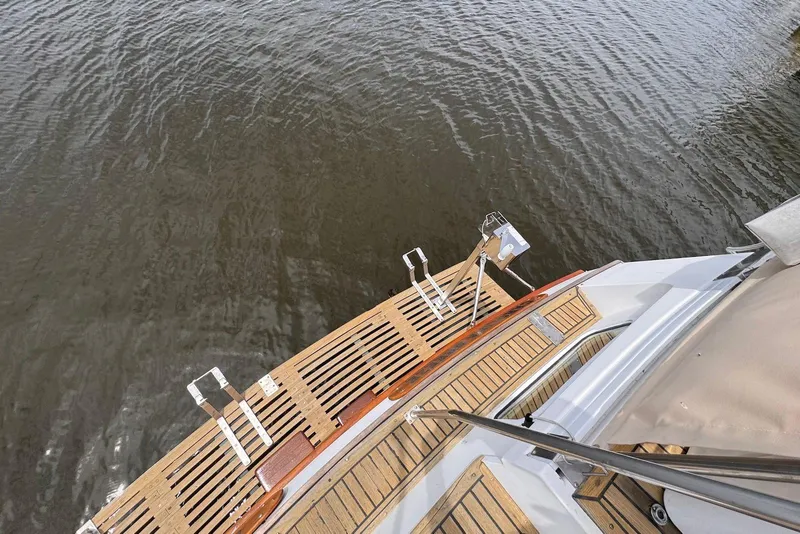 Slide: The Image of Grand Banks 42 Motoryacht 1989, teak swim platform, ladder, and railing over water. - 21