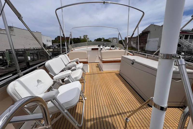 Slide: The Image of 1989 Grand Banks 42 Motoryacht deck with seating and wooden flooring, docked at marina. - 24