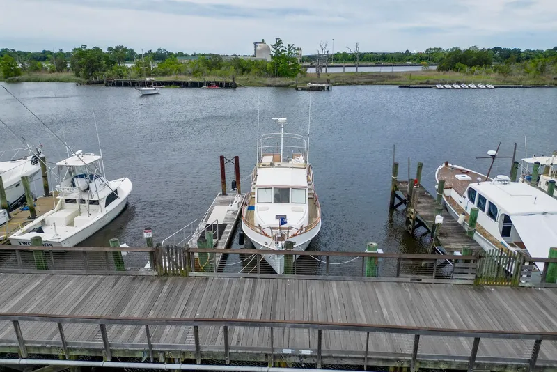Slide: The Image of 1989 Grand Banks 42 Motoryacht docked at a marina, surrounded by other boats. - 3