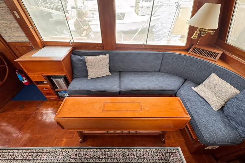 Slide: The Image of Interior of 1989 Grand Banks 42 Motoryacht with blue sofa, wooden table, and nautical decor. - 35
