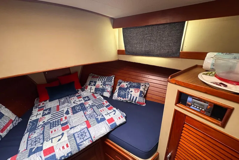 Slide: The Image of Cozy cabin interior of 1989 Grand Banks 42 Motoryacht with nautical-themed bedding. - 39