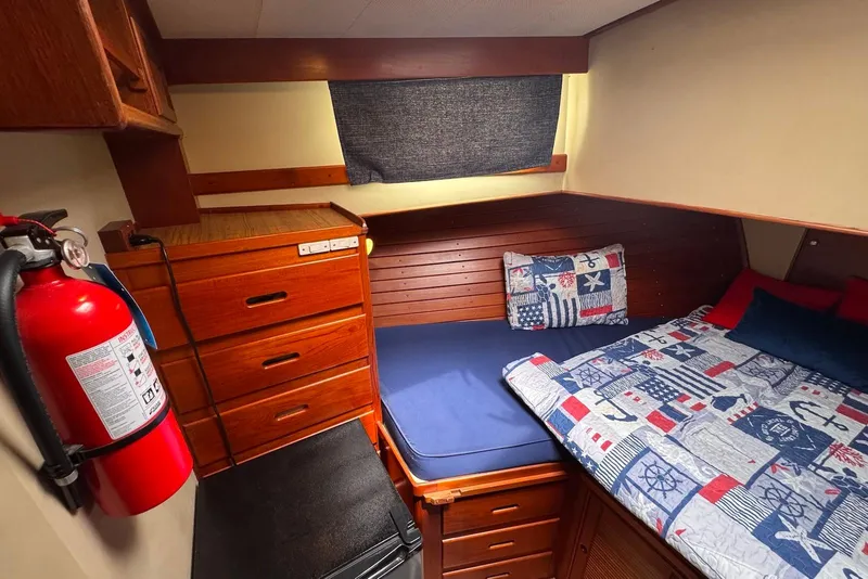 Slide: The Image of Cozy cabin interior of 1989 Grand Banks 42 Motoryacht with nautical-themed bedding and wooden cabinetry. - 41