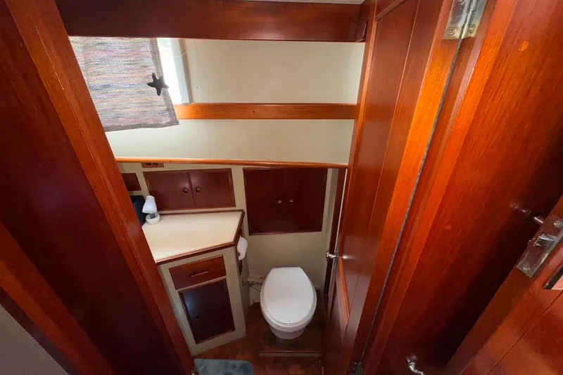 Slide: The Image of Bathroom interior of 1989 Grand Banks 42 Motoryacht with wooden cabinetry and compact design. - 42