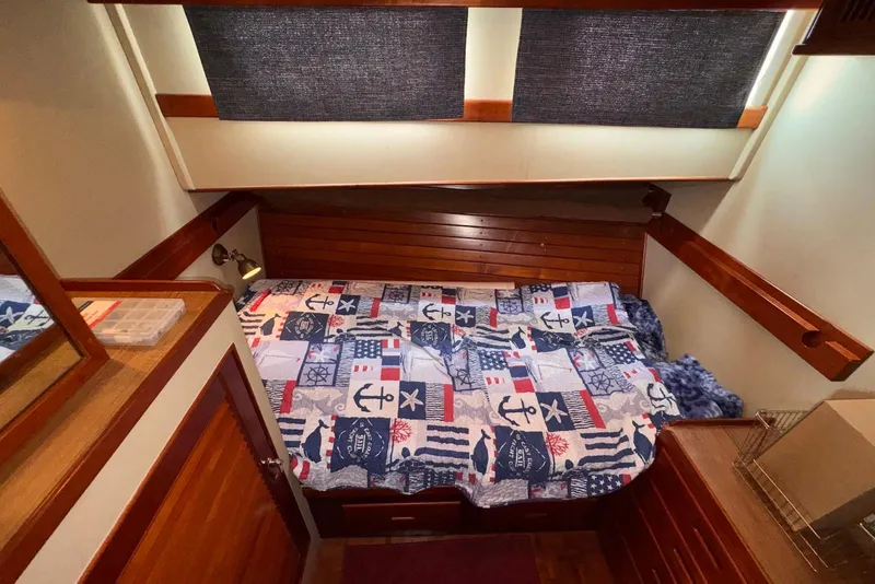 Slide: The Image of Cozy cabin interior of 1989 Grand Banks 42 Motoryacht with nautical-themed bedding. - 48