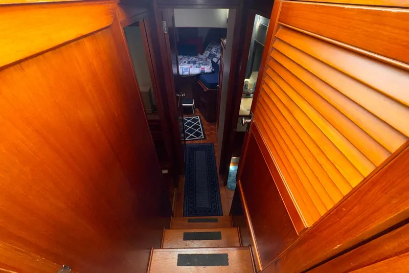 Slide: The Image of Interior view of 1989 Grand Banks 42 Motoryacht, featuring wooden stairs and cozy cabin. - 49