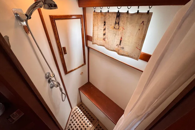 Slide: The Image of Shower area in 1989 Grand Banks 42 Motoryacht with wooden accents and nautical curtain. - 55