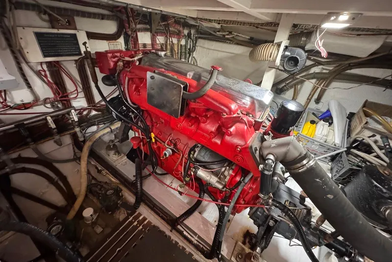 Slide: The Image of Engine room of a 1989 Grand Banks 42 Motoryacht with red engine components. - 58