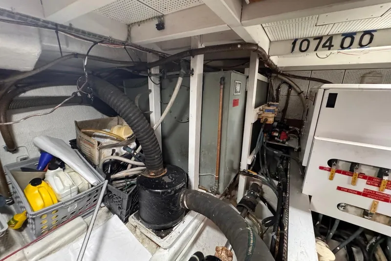 Slide: The Image of Engine room of a 1989 Grand Banks 42 Motoryacht, featuring equipment and storage containers. - 60