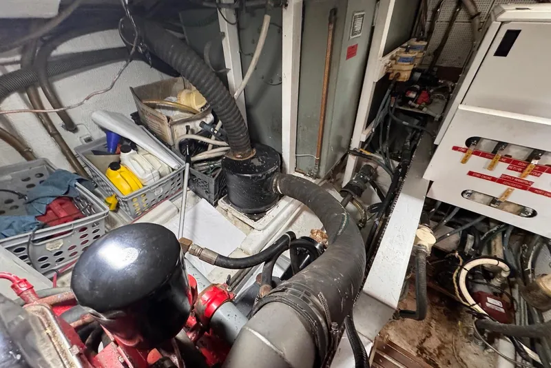 Slide: The Image of Engine room of a 1989 Grand Banks 42 Motoryacht with hoses and storage baskets. - 61