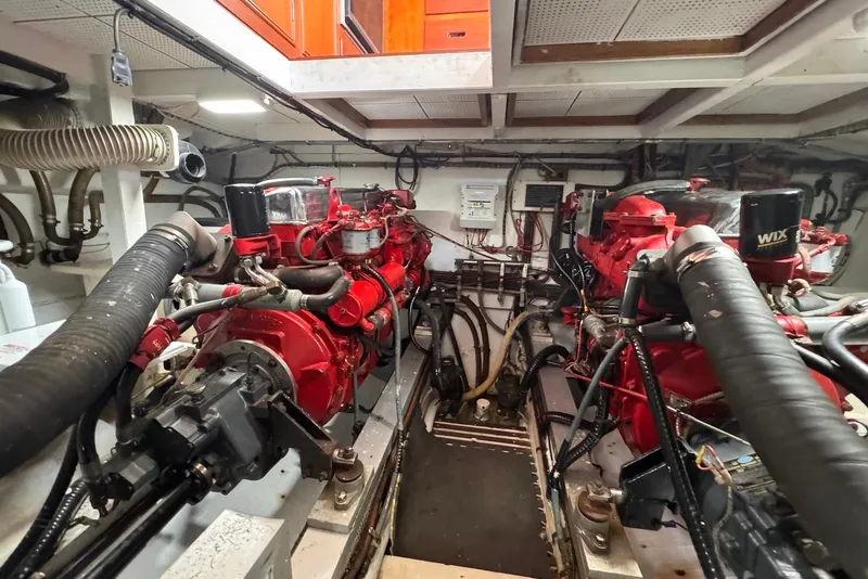 Slide: The Image of Engine room of a 1989 Grand Banks 42 Motoryacht with red machinery and piping. - 67