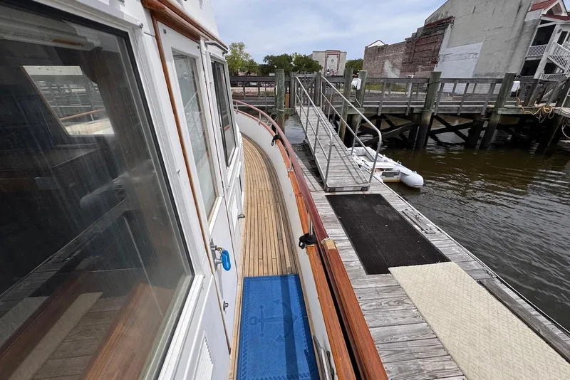 Slide: The Image of 1989 Grand Banks 42 Motoryacht docked, showcasing wooden deck and marina view. - 7