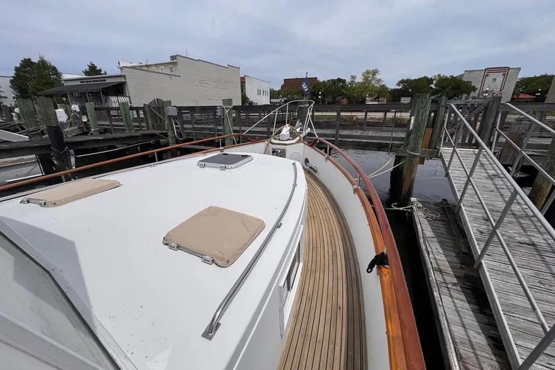 Slide: The Image of 1989 Grand Banks 42 Motoryacht docked, showcasing teak deck and classic design. - 8
