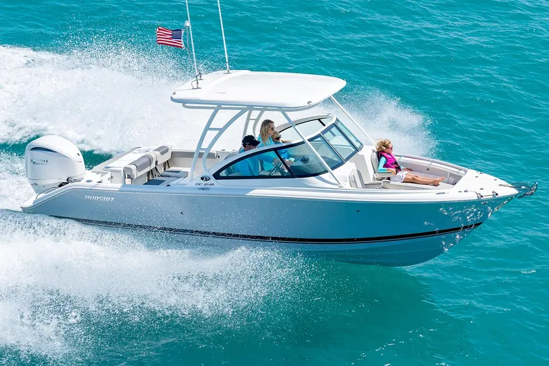Slide: The Image of Manufacturer Provided Image: 2025 Pursuit DC 246 Dual Console boat cruising on clear blue water. - 2