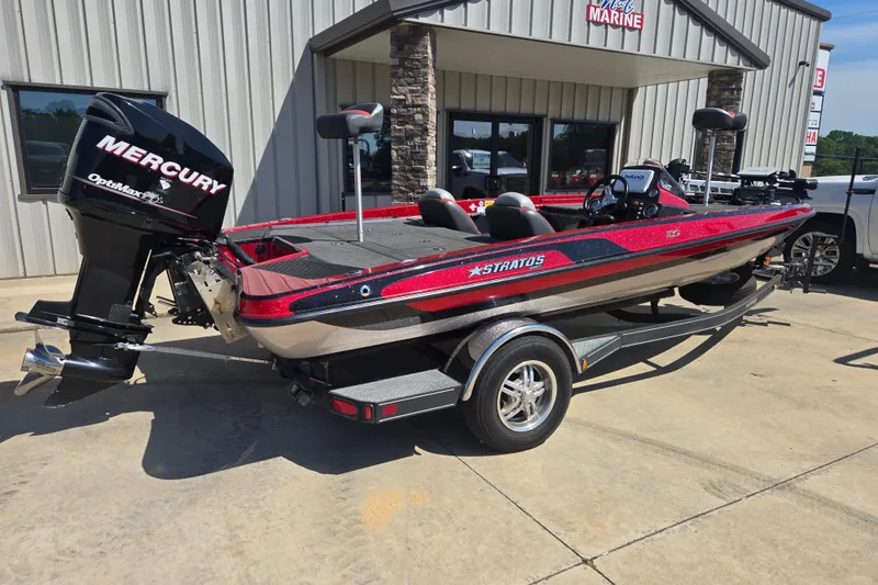 Slide: The Image of 2012 Stratos 189 VLO boat with Mercury OptiMax engine, parked outside a marine shop. - 2